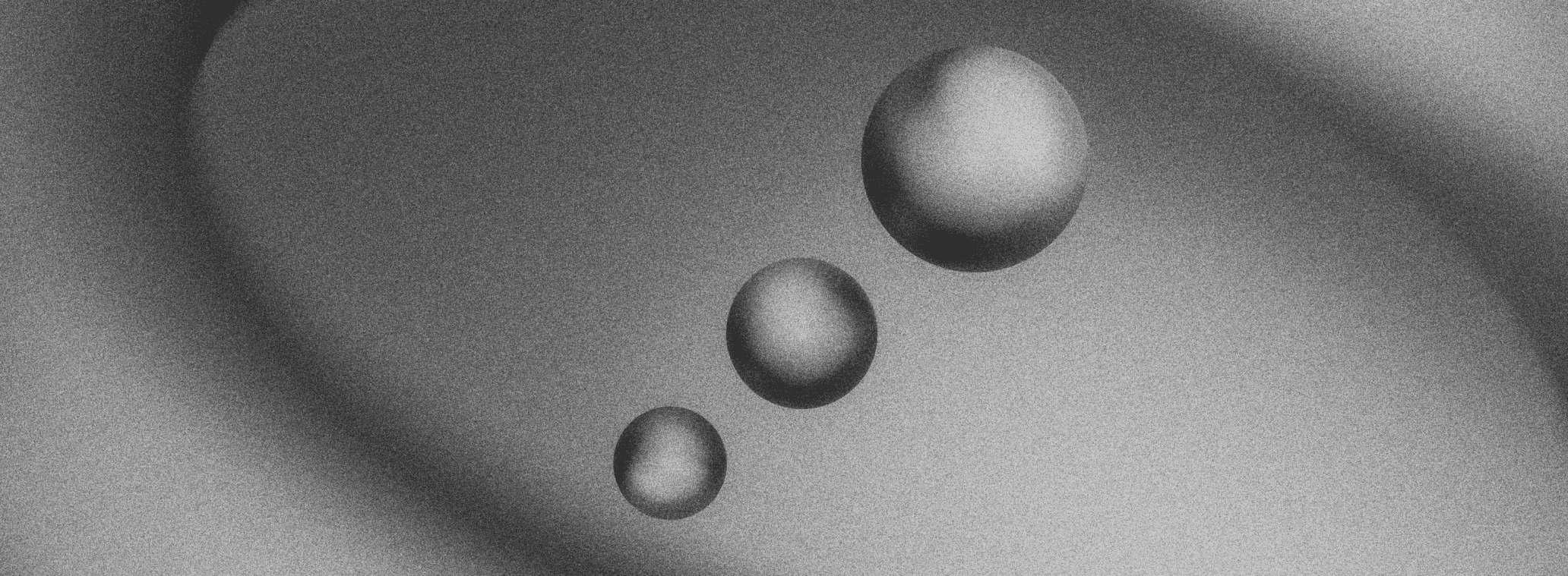 Three smooth, metallic-looking spheres of different sizes float diagonally against a gray, softly textured background with subtle curved shadows.